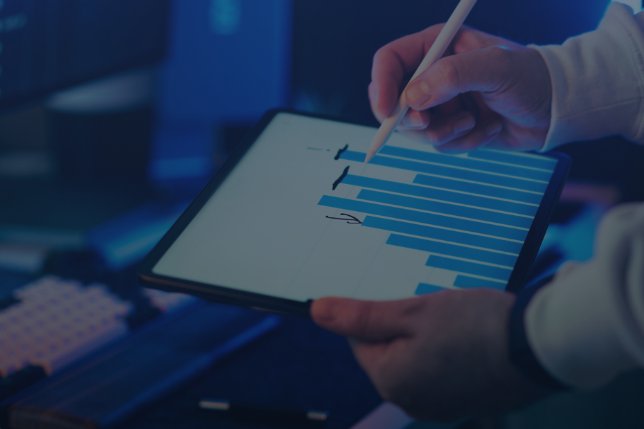 A person using a stylus on a tablet showing a business graph in an office setting.
