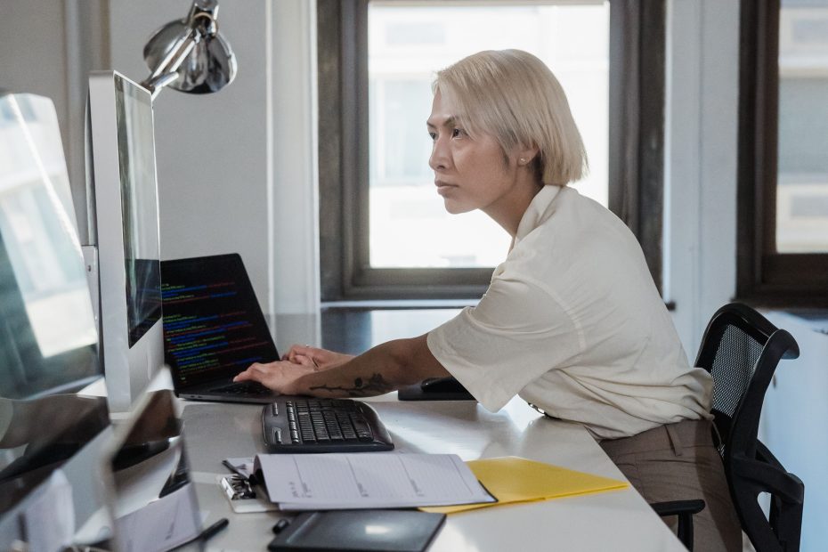 A professional working at a multi-screen desk โ IT strategy consulting starts with understanding your business, not the technology.